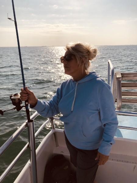 Angler fishing from the boat with the sun low over the water